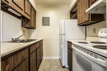 A kitchen with white appliances and cabinets and a white refrigerator